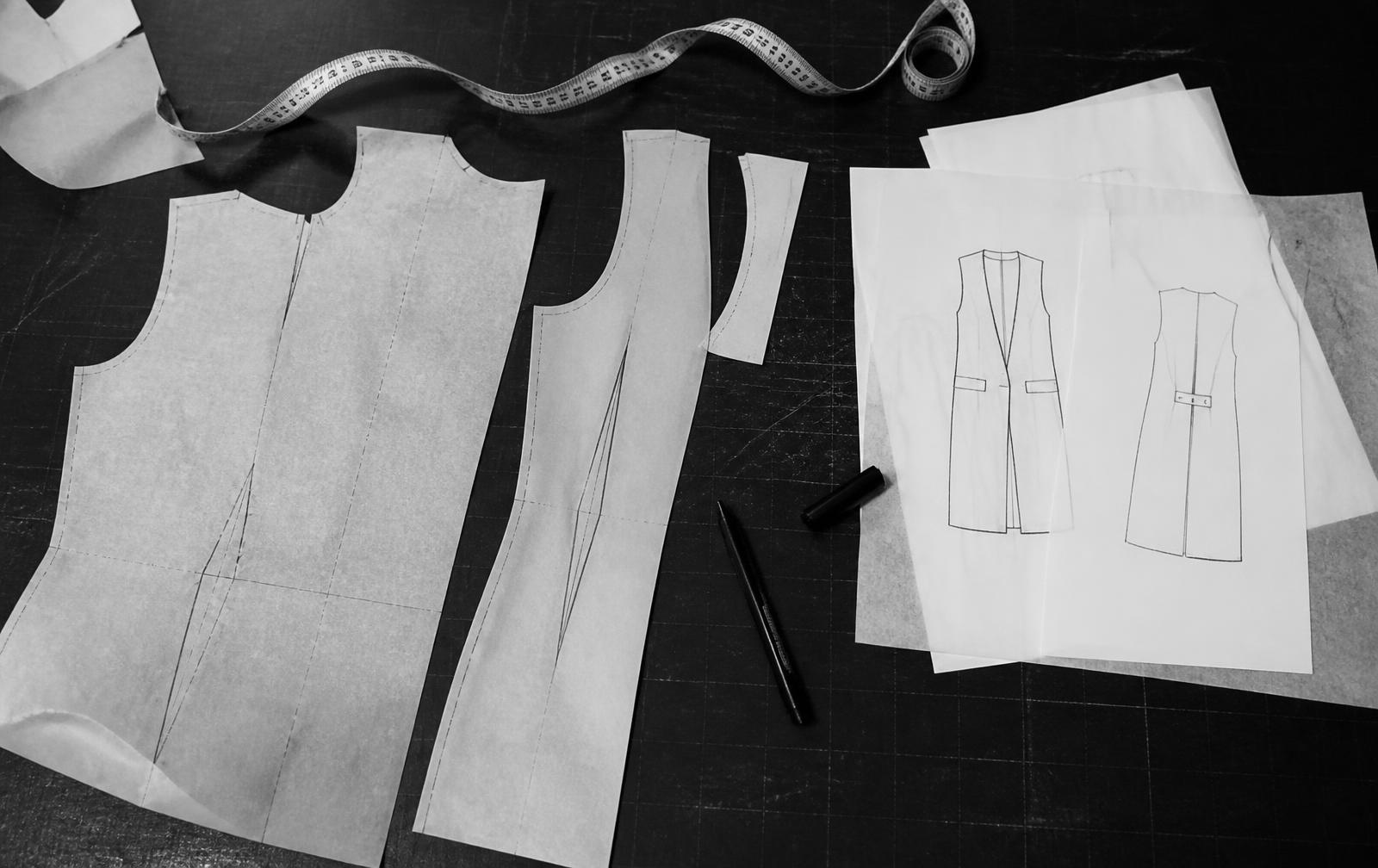 Garment patterns and technical drawings on a cutting table